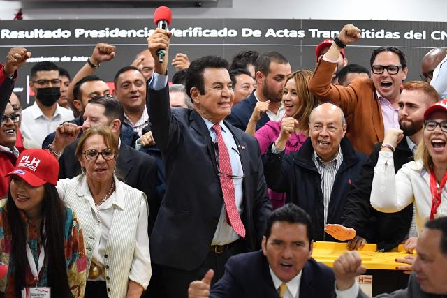 Salvador Nasralla (C), presidential candidate for the opposition Liberal Party, celebrates with his main collaborators next to boxes containing electoral tally sheets during a press conference in Tegucigalpa on December 2, 2025. Honduras' electoral authority, under pressure from US President Donald Trump, said on December 2 that the results of the presidential elections in Honduras will be "scrupulously" respected, where right-wing candidates Nasry Asfura and Salvador Nasralla are in a technical tie. (Photo by Orlando SIERRA / AFP)