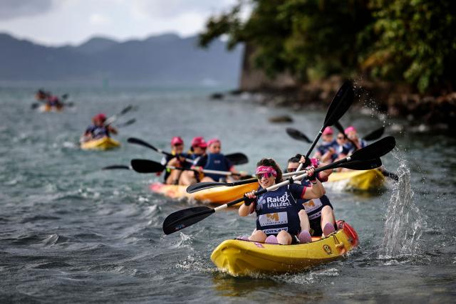 Competitors take part in a kayak race as part of the 'Raid des Alizes', an exclusively all-female multi sport competition, on the French Caribbean island of Martinique, on November 26, 2025. The all-female event features running, mountain biking, kayaking, and trekking events with each team representing a charity project of their choice with the overall ranking determining the prize money which will be directly donated to the charities. (Photo by Anne-Christine POUJOULAT / AFP)