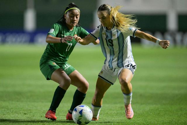 Bolivia's forward #11 Ilsen Rodriguez and Argentina's forward #19 Agostina Holzheier fight for the ball during the Conmebol Women's Nations League 2025-26 football match between Argentina and Bolivia at the Florencio Sola Stadium in Banfield, Buenos Aires province on December 2, 2025. (Photo by JUAN MABROMATA / AFP)