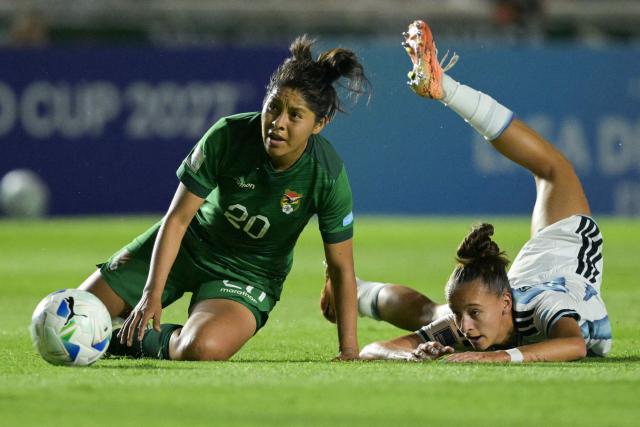 Bolivia's midfielder #20 Sonia Turihuano and Argentina's forward #21 Paulina Gramaglia fall to the ground during the Conmebol Women's Nations League 2025-26 football match between Argentina and Bolivia at the Florencio Sola Stadium in Banfield, Buenos Aires province on December 2, 2025. (Photo by JUAN MABROMATA / AFP)