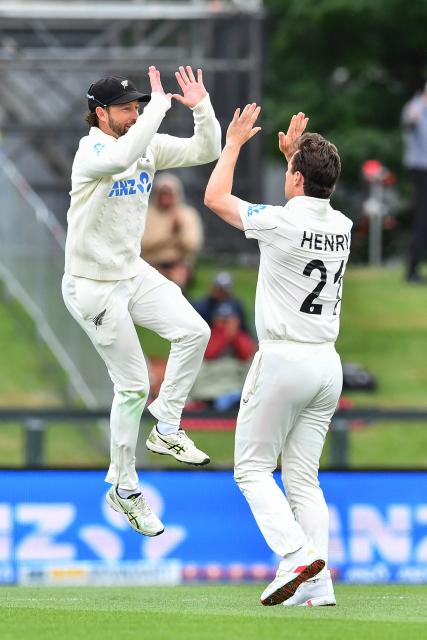 New Zealand's Matt Henry (R) and Devon Conway celebrate the dismissal of West Indies' Justin Greaves during day two of the first Test cricket match between New Zealand and West Indies at Hagley Oval in Christchurch on December 3, 2025. (Photo by Sanka Vidanagama / AFP)