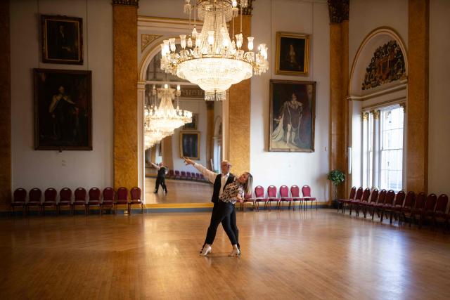 Ballroom dancers practice before taking part in a Tea Dance, in the Main Ballroom of Liverpool Town Hall, in Liverpool, north west England on November 17, 2025. Tea dance, which evolved from the tradition of afternoon tea in the late 19th century, is enjoying a revival, especially since the pandemic. One recent chilly Monday afternoon in the northwest city of Liverpool, 115 dancers paid £12 to waltz, tango and cha-cha-cha under the chandeliers of the stunning 18th century town hall. Refreshments included tea and cakes. (Photo by Oli SCARFF / AFP)