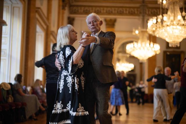 Ballroom dancers take part in a Tea Dance, in the Main Ballroom of Liverpool Town Hall, in Liverpool, north west England on November 17, 2025. Tea dance, which evolved from the tradition of afternoon tea in the late 19th century, is enjoying a revival, especially since the pandemic. One recent chilly Monday afternoon in the northwest city of Liverpool, 115 dancers paid £12 to waltz, tango and cha-cha-cha under the chandeliers of the stunning 18th century town hall. Refreshments included tea and cakes. (Photo by Oli SCARFF / AFP)