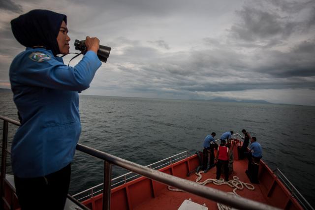 (FILES) A member of Indonesia's National Search and Rescue scans the horizon during a search in the Andaman sea area around the northern tip of Indonesia's Sumatra island for the missing Malaysia Airlines flight MH370 on March 17, 2014. The search for missing Malaysia Airlines flight MH370 will resume at the end of December, Malaysia's transport ministry said on December 3, 2025, more than a decade after the plane disappeared. (Photo by CHAIDEER MAHYUDDIN / AFP)