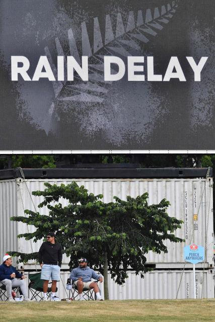 Fans look on as rain delays play during day two of the first Test cricket match between New Zealand and West Indies at Hagley Oval in Christchurch on December 3, 2025. (Photo by Sanka Vidanagama / AFP)