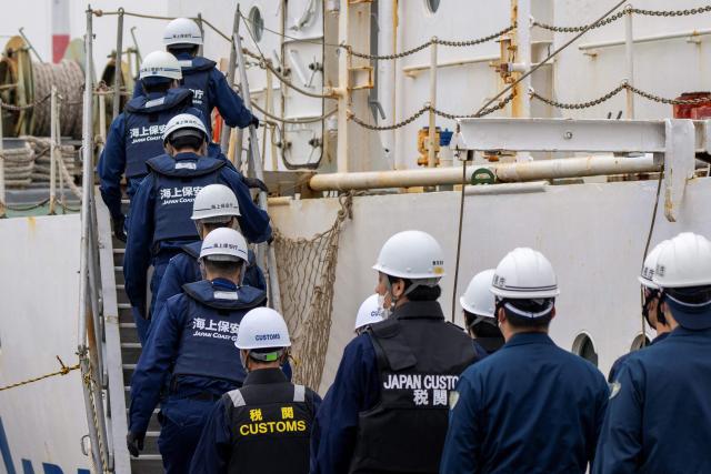 Officials from the Japan Coast Guard, customs, and police board the suspicious ship to inspect its cargo during the PSI (Proliferation Security Initiative) maritime interdiction exercise Pacific "Shield 25" as part of the training at a port in Tokyo on December 3, 2025. (Photo by Kazuhiro NOGI / AFP)