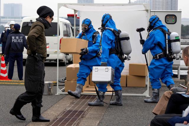 Police officers in protective gear discover a suspicious substance in the cargo during the PSI (Proliferation Security Initiative) maritime interdiction exercise Pacific "Shield 25" as part of the training at a port in Tokyo on December 3, 2025. (Photo by Kazuhiro NOGI / AFP)