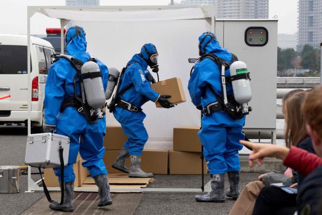 Police officers in protective gear discover a suspicious substance in the cargo during the PSI (Proliferation Security Initiative) maritime interdiction exercise Pacific "Shield 25" as part of the training at a port in Tokyo on December 3, 2025. (Photo by Kazuhiro NOGI / AFP)