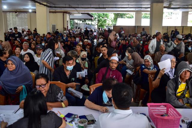 Flood victims register to receive disaster relief funds at the Narathiwat municipality building in Thailand's southern province of Narathiwat on December 3, 2025, after severe flooding affected thousands of people in the region. Heavy rains in the annual monsoon season, exacerbated by a tropical storm in the region, inundated parts of southern Thailand in late November, killing dozens and trapping many in their homes. (Photo by Madaree TOHLALA / AFP)