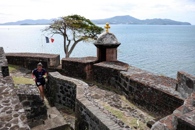 TOPSHOT - A competitor takes part in an orientation run during the "Raid des Alizes", an exclusively all-female multi sport competition, at the Fort Saint Louis on the French Caribbean island of Martinique, on November 26, 2025. The all-female event features running, mountain biking, kayaking, and trekking events with each team representing a charity project of their choice with the overall ranking determining the prize money which will be directly donated to the charities. (Photo by Anne-Christine POUJOULAT / AFP)