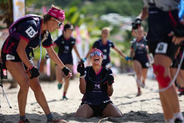 Competitors of team Les Ensoleilleuses react as they cross the finish line of the "Raid des Alizes", an exclusively all-female multi sport competition on the French Caribbean island of Martinique, on November 29, 2025. The all-female event features running, mountain biking, kayaking, and trekking events with each team representing a charity project of their choice with the overall ranking determining the prize money which will be directly donated to the charities. (Photo by Anne-Christine POUJOULAT / AFP)