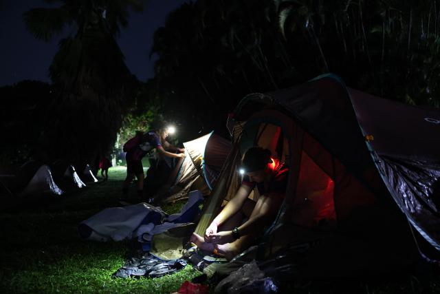 Team Les fanm Djok 973's Delphine Boudairon prepares her equipment at the camping site to compete in the "Raid des Alizes", an exclusively all-female multi sport competition, on the French Caribbean island of Martinique, on November 28, 2025. The all-female event features running, mountain biking, kayaking, and trekking events with each team representing a charity project of their choice with the overall ranking determining the prize money which will be directly donated to the charities. (Photo by Anne-Christine POUJOULAT / AFP)