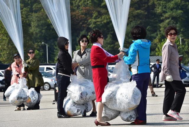 (FILES) South Korean activists prepare to release balloons carrying anti-North Korea leaflets at a park near the inter-Korea border in Paju, north of Seoul on October 10, 2014. South Korea has passed a law banning unmanned balloons from no-fly zones, Seoul's unification ministry said December 3, 2025, in a move expected to curb activists from flying anti-Pyongyang leaflets across the border. (Photo by Jung Yeon-je / AFP)