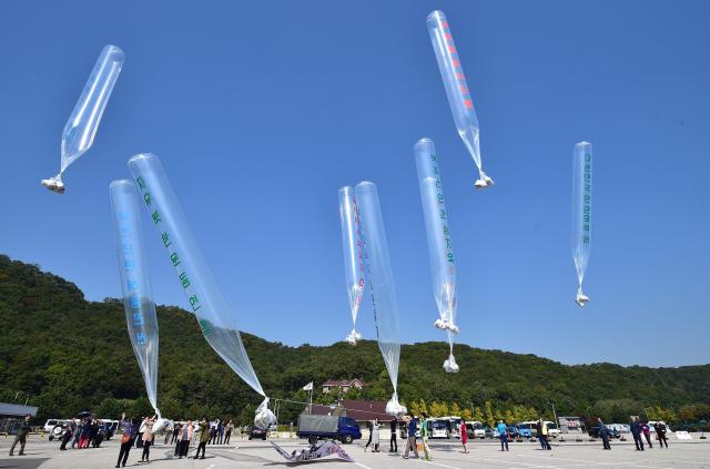 (FILES) South Korean activists release balloons carrying anti-North Korea leaflets at a park near the inter-Korea border in Paju, north of Seoul on October 10, 2014. South Korea has passed a law banning unmanned balloons from no-fly zones, Seoul's unification ministry said December 3, 2025, in a move expected to curb activists from flying anti-Pyongyang leaflets across the border. (Photo by Jung Yeon-je / AFP)