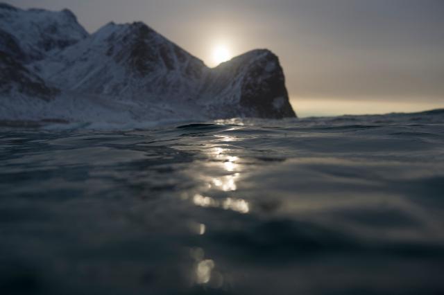 (FILES) Snow covered mountains are seen from the waters of Unstad along the northern Atlantic Ocean on March 12, 2017, where the water temperatures is at five degrees centigrade and the air temperature is at minus two degrees centigrade. Norway, the first European country to open parts of its waters to deep-sea mining, will not issue the first licenses for another four years, according to a political deal reached on December 3, 2025. (Photo by OLIVIER MORIN / AFP)