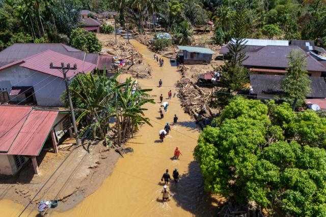 This picture shows an aerial view of villagers wading through the mudflow to find a shelter in the aftermath of flash floods in Tukka village, Central Tapanuli, North Sumatra province, on December 3, 2025. Officials in Indonesia and Sri Lanka battled on December 3 to reach survivors of deadly flooding in remote, cut-off regions as the toll in the disaster that hit four countries topped 1,300. In Indonesia, there is growing frustration among survivors of catastrophic flooding and landslides over the pace of the rescue effort and aid delivery. (Photo by YT Hariono / AFP)
