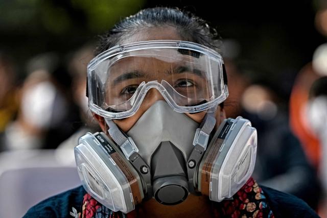 A demonstrator wearing a mask takes part in a protest demanding the government take action to reduce air pollution in New Delhi on December 3, 2025. (Photo by Sajjad HUSSAIN / AFP)