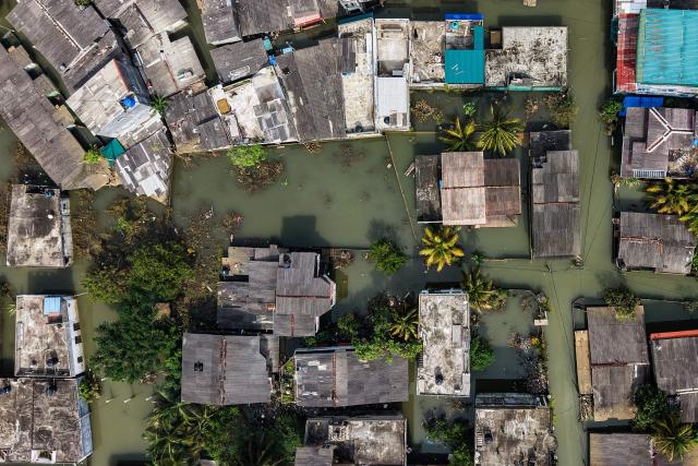 An aerial view shows houses partially submerged in floodwaters following heavy rainfall in the aftermath of Cyclone Ditwah in Wellampitiya on the outskirts of Colombo on December 3, 2025. (Photo by AFP)