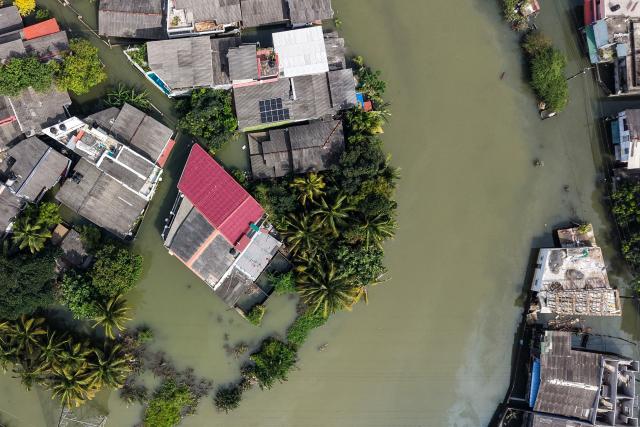 TOPSHOT - An aerial view shows houses partially submerged in floodwaters following heavy rainfall in the aftermath of Cyclone Ditwah in Wellampitiya on the outskirts of Colombo on December 3, 2025. Sri Lankan authorities said on December 3 they would need some $7 billion to rebuild homes, industries and roads destroyed by Cyclone Ditwah, which has left at least 465 people dead so far. (Photo by AFP)