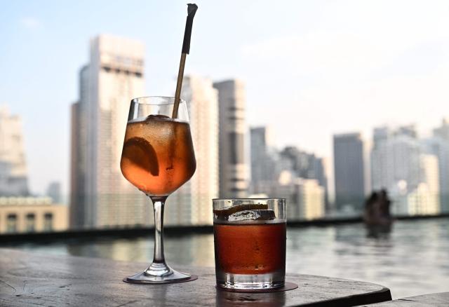 Alcoholic drinks are seen at a rooftop bar in Bangkok on December 3, 2025. Thailand on December 3 relaxed decades-old alcohol sales restrictions, allowing consumers to buy wine, beer and spirits during previously prohibited afternoon hours in a six-month trial. (Photo by Lillian SUWANRUMPHA / AFP)