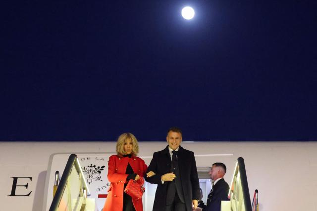 TOPSHOT - France's President Emmanuel Macron (R) and his wife Brigitte Macron disembark from their plane upon their arrival at the Capital International Airport in Beijing on December 3, 2025. French President Emmanuel Macron touched down on December 3 in China, an AFP journalist saw, where he is expected to put pressure on his counterpart Xi Jinping to help secure a ceasefire in Ukraine and discuss trade relations. (Photo by Ludovic MARIN / POOL / AFP)