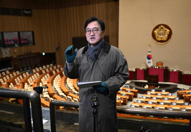 National Assembly Speaker Woo Won-shik (C) guides visitors during a dark tour on martial law sites to mark the first anniversary of the declaration of martial law by ousted president Yoon Suk Yeol, at the National Assembly in Seoul on December 3, 2025. Yoon suspended civilian rule in South Korea on December 3, 2024, for the first time in more than four decades, prompting massive protests and a showdown in parliament. A year later, the country remains politically polarised as it faces a slowing economy and an ageing population, as well as the lingering threat from North Korea. (Photo by JUNG YEON-JE / POOL / AFP)