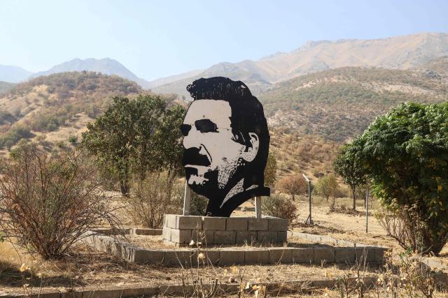 (FILES) This photograph shows a cutout portrait of jailed leader of the Kurdistan Workers' Party (PKK) Abdullah Ocalan during a ceremony in the Qandil area of northern Iraq, where the militant group announced its complete withdrawal of forces from Turkey, on October 26, 2025. Jailed PKK founder Abdullah Ocalan stressed his determination to see through ongoing peace efforts with Turkey, while urging Ankara to finalise the legal groundwork for the process in remarks published on December 3, 2025. (Photo by Shwan MOHAMMED / AFP)
