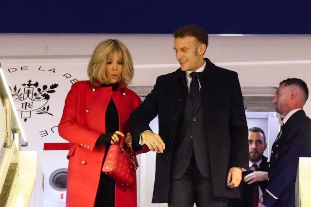 France's President Emmanuel Macron (R) and his wife Brigitte Macron disembark from their plane upon their arrival at the Capital International Airport in Beijing on December 3, 2025. French President Emmanuel Macron touched down on December 3 in China, an AFP journalist saw, where he is expected to put pressure on his counterpart Xi Jinping to help secure a ceasefire in Ukraine and discuss trade relations. (Photo by Ludovic MARIN / POOL / AFP)