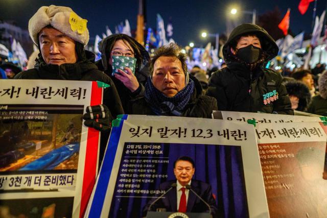 Protesters take part in a rally near the National Assembly in Seoul on December 3, 2025, to mark the first anniversary of the declaration of martial law by ousted president Yoon Suk Yeol. Yoon suspended civilian rule in South Korea on December 3, 2024, for the first time in more than four decades, prompting massive protests and a showdown in parliament. A year later, the country remains politically polarised as it faces a slowing economy and an ageing population, as well as the lingering threat from North Korea. (Photo by ANTHONY WALLACE / AFP)