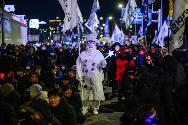 Protesters take part in a rally near the National Assembly in Seoul on December 3, 2025, to mark the first anniversary of the declaration of martial law by ousted president Yoon Suk Yeol. Yoon suspended civilian rule in South Korea on December 3, 2024, for the first time in more than four decades, prompting massive protests and a showdown in parliament. A year later, the country remains politically polarised as it faces a slowing economy and an ageing population, as well as the lingering threat from North Korea. (Photo by ANTHONY WALLACE / AFP)