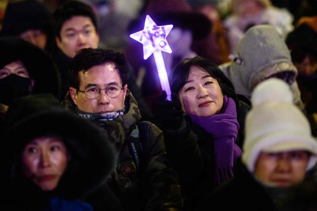 Protesters take part in a rally near the National Assembly in Seoul on December 3, 2025, to mark the first anniversary of the declaration of martial law by ousted president Yoon Suk Yeol. Yoon suspended civilian rule in South Korea on December 3, 2024, for the first time in more than four decades, prompting massive protests and a showdown in parliament. A year later, the country remains politically polarised as it faces a slowing economy and an ageing population, as well as the lingering threat from North Korea. (Photo by ANTHONY WALLACE / AFP)
