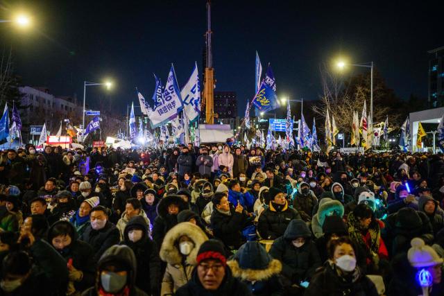 Protesters take part in a rally near the National Assembly in Seoul on December 3, 2025, to mark the first anniversary of the declaration of martial law by ousted president Yoon Suk Yeol. Yoon suspended civilian rule in South Korea on December 3, 2024, for the first time in more than four decades, prompting massive protests and a showdown in parliament. A year later, the country remains politically polarised as it faces a slowing economy and an ageing population, as well as the lingering threat from North Korea. (Photo by ANTHONY WALLACE / AFP)