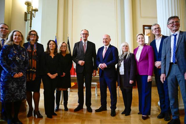 Berlin's mayor Kai Wegner (CR) and members of Berlin's senate pose with German Chancellor Friedrich Merz (C) during his first official visit as Chancellor in the federal state of Berlin at the so-called Rotes Rathaus (Red City Hall) in the German capital, on December 3, 2025. (Photo by John MACDOUGALL / AFP)