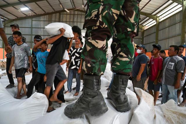 Villagers receive free sacks of rice from the Indonesian military, distributed amid relief efforts from the government's rice warehouse at Sarudik, in Central Tapanuli, North Sumatra province, on December 3, 2025. Officials in Indonesia and Sri Lanka battled on December 3 to reach survivors of deadly flooding in remote, cut-off regions as the toll in the disaster that hit four countries topped 1,300. In Indonesia, there is growing frustration among survivors of catastrophic flooding and landslides over the pace of the rescue effort and aid delivery. (Photo by YT Hariono / AFP)