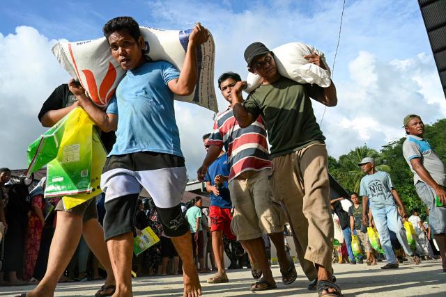 Villagers receive free sacks of rice from the Indonesian military, distributed amid relief efforts from the government's rice warehouse at Sarudik, in Central Tapanuli, North Sumatra province, on December 3, 2025. Officials in Indonesia and Sri Lanka battled on December 3 to reach survivors of deadly flooding in remote, cut-off regions as the toll in the disaster that hit four countries topped 1,300. In Indonesia, there is growing frustration among survivors of catastrophic flooding and landslides over the pace of the rescue effort and aid delivery. (Photo by YT Hariono / AFP)