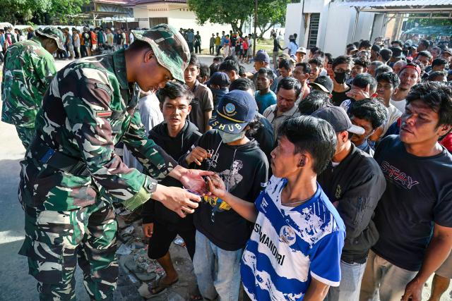 Villagers receive free sacks of rice from the Indonesian military, distributed amid relief efforts from the government's rice warehouse at Sarudik, in Central Tapanuli, North Sumatra province, on December 3, 2025. Officials in Indonesia and Sri Lanka battled on December 3 to reach survivors of deadly flooding in remote, cut-off regions as the toll in the disaster that hit four countries topped 1,300. In Indonesia, there is growing frustration among survivors of catastrophic flooding and landslides over the pace of the rescue effort and aid delivery. (Photo by YT Hariono / AFP)
