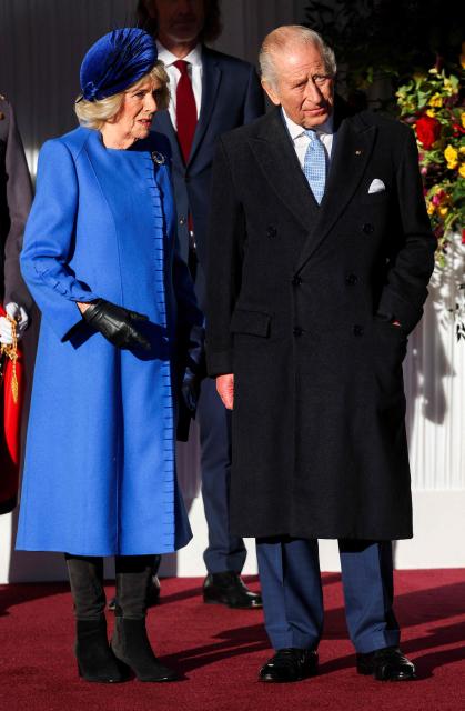 Britain's King Charles III and Britain's Queen Camilla wait talk as they wait for the arrival of Germany's President in the grounds of Windsor Castle in Windsor, on December 3, 2025, the first day of a three day state visit by the German President. (Photo by Toby Melville / POOL / AFP)