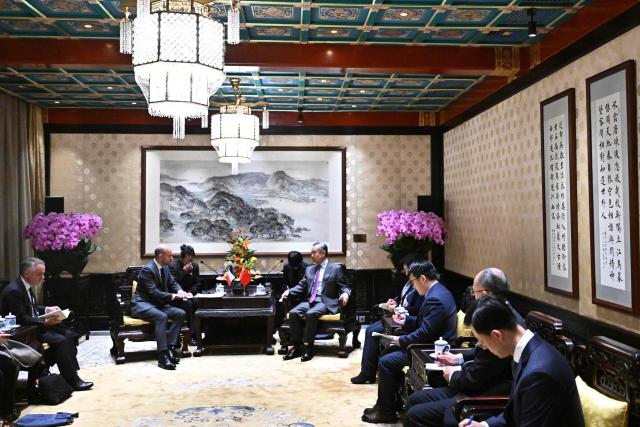 France's Foreign Affairs Minister Jean-Noel Barrot (centre, L) and China's Foreign Minister Wang Yi (centre, R) hold a meeting at the Diaoyutai State Guesthouse in Beijing on December 3, 2025. French President Emmanuel Macron touched down on December 3 in China, an AFP journalist saw, where he is expected to put pressure on his counterpart Xi Jinping to help secure a ceasefire in Ukraine and discuss trade relations. (Photo by Pedro PARDO and Pedro Pardo / POOL / AFP)
