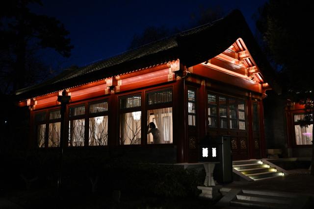 An assistant looks out the window prior to the meeting between France's Foreign Affairs Minister Jean-Noel Barrot and China's Foreign Minister Wang Yi at the Diaoyutai State Guesthouse in Beijing on December 3, 2025. French President Emmanuel Macron touched down on December 3 in China, an AFP journalist saw, where he is expected to put pressure on his counterpart Xi Jinping to help secure a ceasefire in Ukraine and discuss trade relations. (Photo by Pedro PARDO and Pedro Pardo / POOL / AFP)