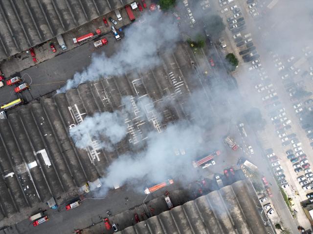 Aerial view of an active fire at the Rio de Janeiro State Food Distribution Center (CEASA) at Iraja neighborhood in Rio de Janeiro, Brazil on December 3, 2025. (Photo by PABLO PORCIUNCULA / AFP)