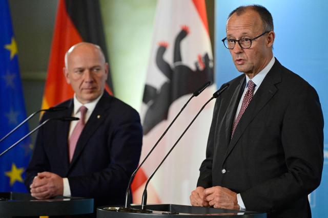 Berlin's mayor Kai Wegner (L) and German Chancellor Friedrich Merz address journalists during Merz' first official visit as Chancellor in the federal state of Berlin at the so-called Rotes Rathaus (Red City Hall) in the German capital, on December 3, 2025. (Photo by John MACDOUGALL / AFP)
