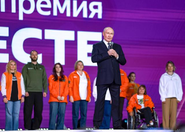 In this pool photograph distributed by the Russian state agency Sputnik, Russia's President Vladimir Putin attends a volunteer organisations forum in Moscow on December 3, 2025. (Photo by Alexander SHCHERBAK / POOL / AFP)