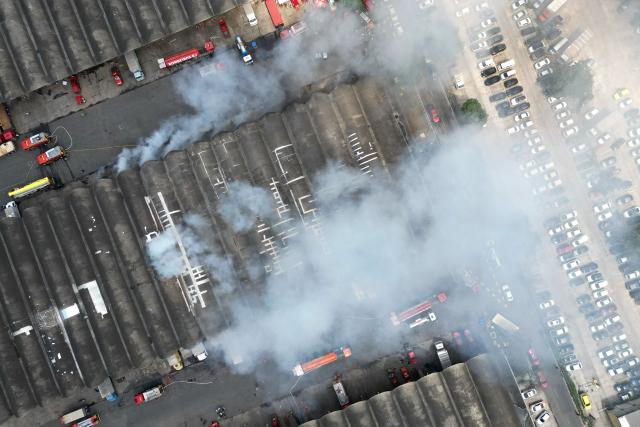 Aerial view of an active fire at the Rio de Janeiro State Food Distribution Center (CEASA) at Iraja neighborhood in Rio de Janeiro, Brazil on December 3, 2025. (Photo by PABLO PORCIUNCULA / AFP)