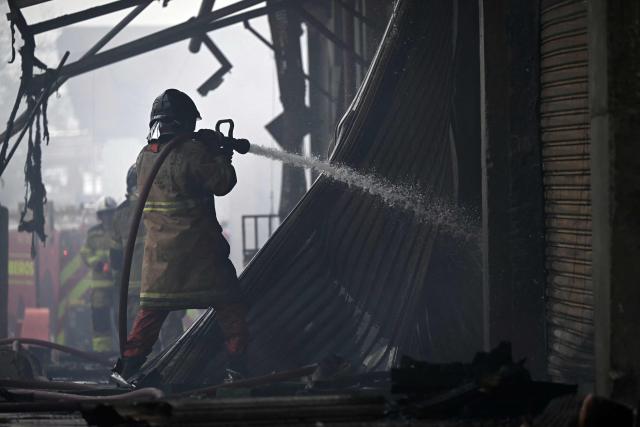 Firefighters try to control a fire at the Rio de Janeiro State Food Distribution Center (CEASA) at Iraja neighborhood in Rio de Janeiro, Brazil on December 3, 2025. (Photo by MAURO PIMENTEL / AFP)