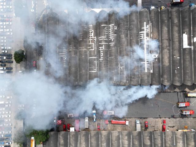 Aerial view of an active fire at the Rio de Janeiro State Food Distribution Center (CEASA) at Iraja neighborhood in Rio de Janeiro, Brazil on December 3, 2025. (Photo by MAURO PIMENTEL / AFP)