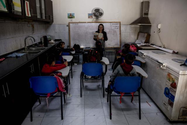 Young learners listen to an educator during the start of classes at Latin Patriarchate School inside the Holy Family Catholic Church compound sheltering displaced Palestinians in Gaza City, on December 3, 2025. Israel said on December 3, it would open the Rafah crossing from Gaza to Egypt to allow residents to exit the Palestinian territory "in the coming days," but Egypt denied such a deal with Israel. (Photo by Omar AL-QATTAA / AFP)