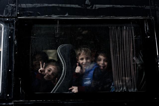 Children react inside a bus at the Holy Family Catholic Church compound sheltering displaced Palestinians in Gaza City, on December 3, 2025. Israel said on December 3, it would open the Rafah crossing from Gaza to Egypt to allow residents to exit the Palestinian territory "in the coming days," but Egypt denied such a deal with Israel. (Photo by Omar AL-QATTAA / AFP)