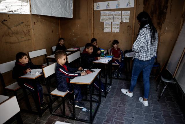 A displaced Palestinian woman prepares Christmas decorations in a shelter at the Holy Family Catholic Church compound in Gaza City, on December 3, 2025. Israel said on December 3, it would open the Rafah crossing from Gaza to Egypt to allow residents to exit the Palestinian territory "in the coming days," but Egypt denied such a deal with Israel. (Photo by Omar AL-QATTAA / AFP)