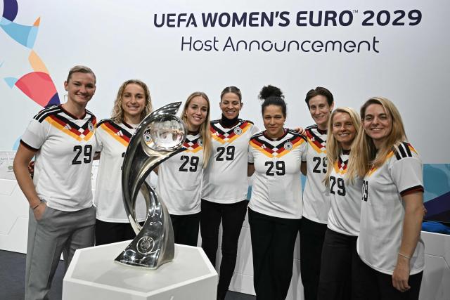 German soccer player Vanessa Diehm, Germany's defender Giulia Gwinn, Vice-President (Equality and diversity) of the German Football Association (DFB) Celia Sasic, Germany's goalkeeper Ann-Katrin Berger and Former German soccer player Nia Kuenzer pose with the trophy after Germany was elected to host the UEFA Women's EURO 2029 fooball tournament during an announcement ceremony at the UEFA headquarters, the House of European Football, in Nyon on December 3, 2025.  (Photo by Fabrice COFFRINI / AFP)