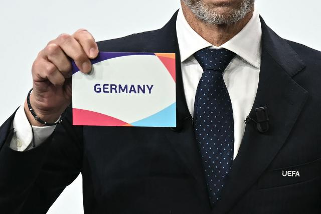 UEFA president Aleksander Ceferin shows the name of Germany, elected to host the UEFA Women's EURO 2029 fooball tournament during an announcement ceremony at the UEFA headquarters, the House of European Football, in Nyon on December 3, 2025.  (Photo by Fabrice COFFRINI / AFP)
